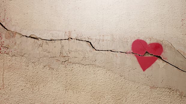 A heart painted on a cracked wall. The concept of broken heart, relationships, love, friendship, marriage, graffiti.