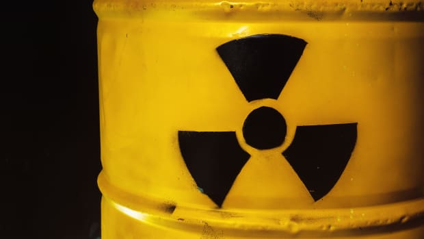 Yellow metal barrel with radioactive decay symbol. Container with nuclear trefoil warning sign. Drum with toxic hazardous waste. Disposal, utilization problem. Environmental harm